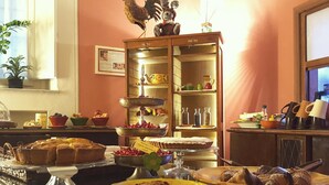 A breakfast buffet with various pastries, fruits, and a decorative rooster. - Hotel Diana (Lucca)