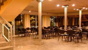 Un salón de conferencias con filas de sillas y una escalera que sube a un nivel superior.
