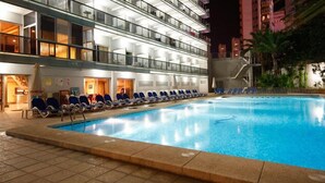 A hotel pool area with lounge chairs and a clear pool. - Hotel Perla (Benidorm)