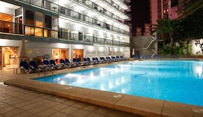 A hotel pool area with lounge chairs and a clear pool. - Hotel Perla (Benidorm)