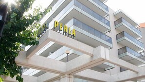 Un edifici modern amb el nom 'PERLA' ben visible a la façana.