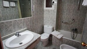 A bathroom with a sink, toilet, bathtub, and a mirror. - Hotel Perla (Benidorm)