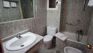 A bathroom with a sink, toilet, bathtub, and a mirror. - Hotel Perla (Benidorm)