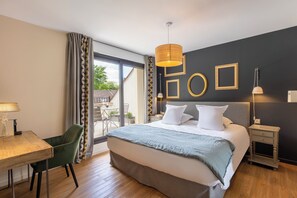 Ett hotellrum med en säng, ett sängbord, en lampa, en stol och utsikt över omgivningarna.