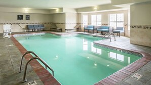 An indoor swimming pool with a pool lift, lounge chairs, and a tiled floor with depth markers. - Homewood Suites by Hilton Cedar Rapids-North (Cedar Rapids)
