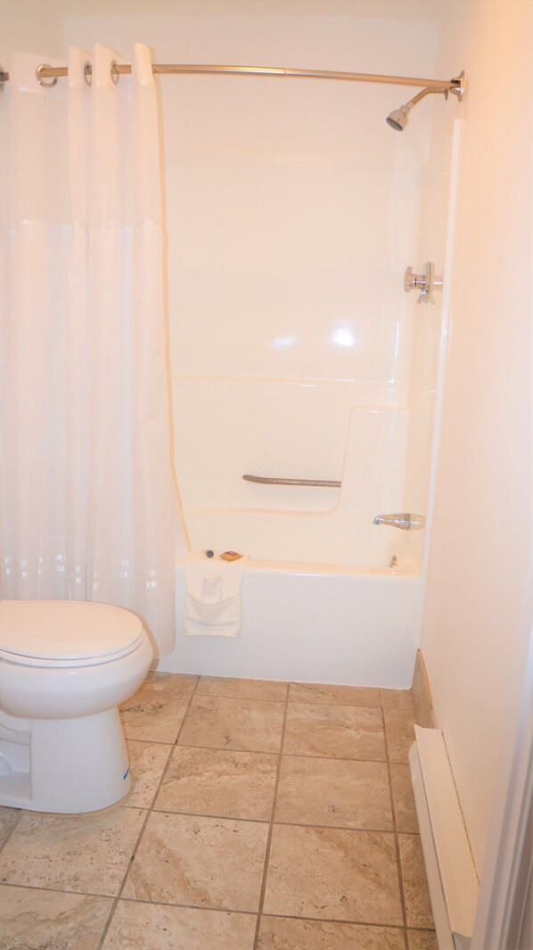 Un baño con inodoro, bañera y ducha.