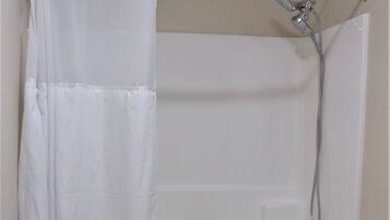 Un baño con bañera, ducha e inodoro.