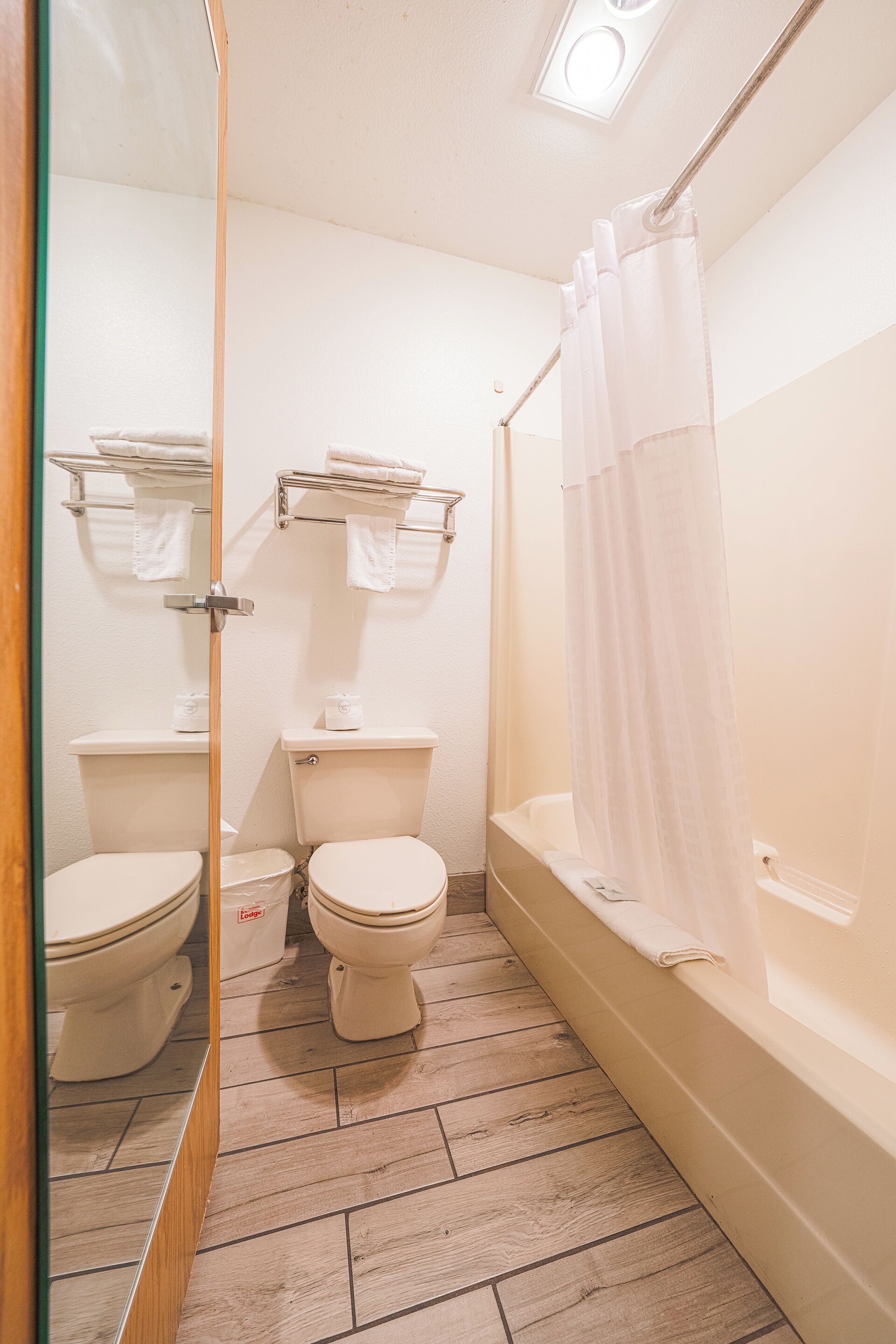 A bathroom with a toilet, a bathtub, and a shower curtain.