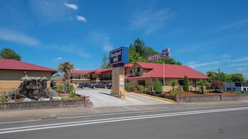 A motel with a red roof and a sign that reads "Budget Inn."