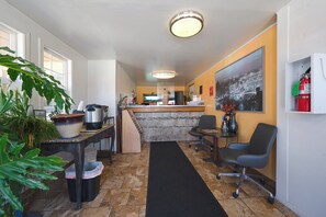 Welcome to our lobby, featuring a reception desk, comfortable seating area, and a beautiful painting on the wall.