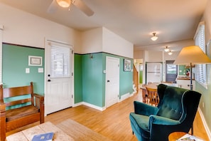 Cozy living area with a plush armchair and wooden bench, dining table, and staircase.