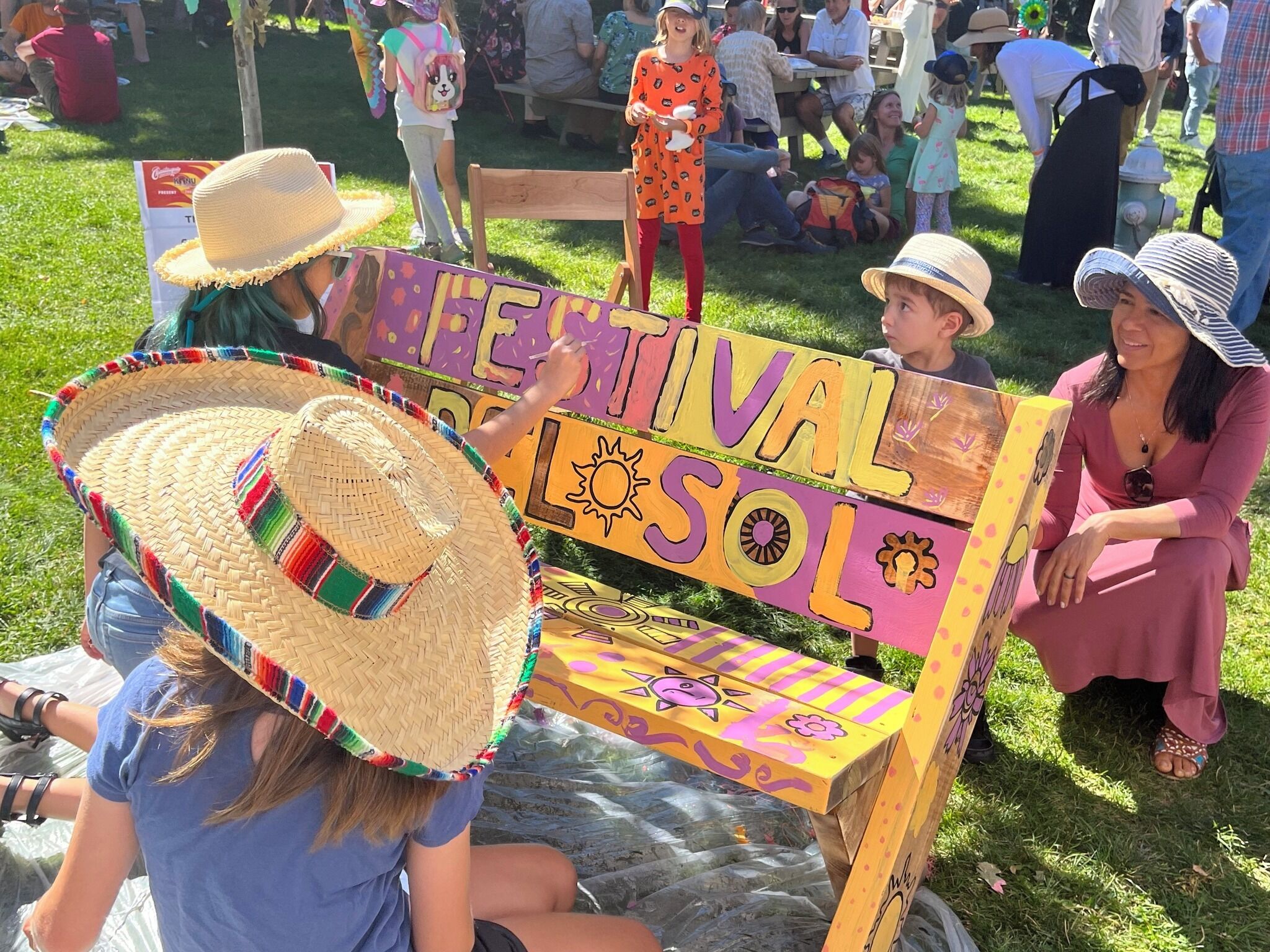 A colorful wooden bench with a sign that reads "FESTIVAL SOL."