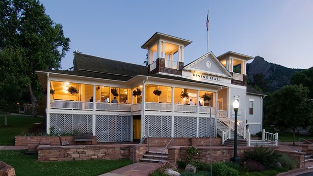 A dining hall with a balcony, a staircase, and a mountain backdrop. - Colorado Chautauqua (Boulder)