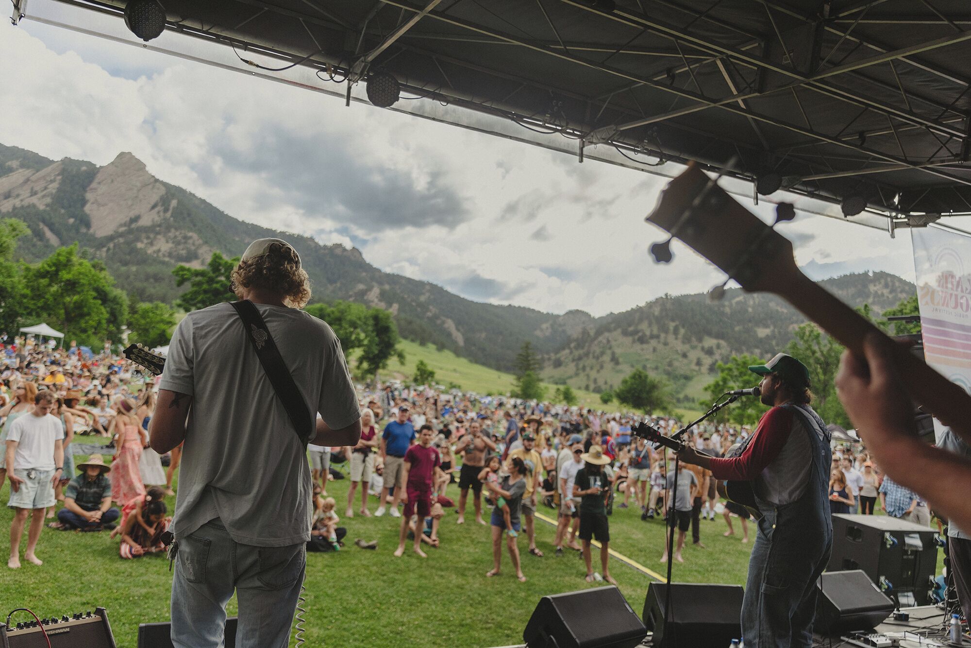 A stage with a crowd, a mountainous backdrop, and a clear sky.