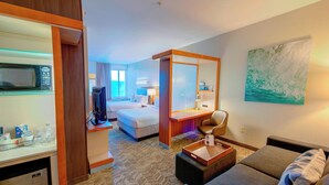 A hotel room with a bed, a desk, a chair, a microwave, and a large window. - SpringHill Suites by Marriott Macon (Macon)