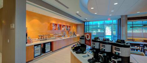 A coffee shop with a counter, coffee machines, and a display of coffee cups.