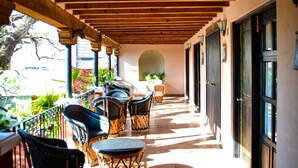 A covered outdoor patio with wooden beams, tiled flooring, and outdoor seating. - Hotel Ana Catalina & Suites (San Miguel de Allende)