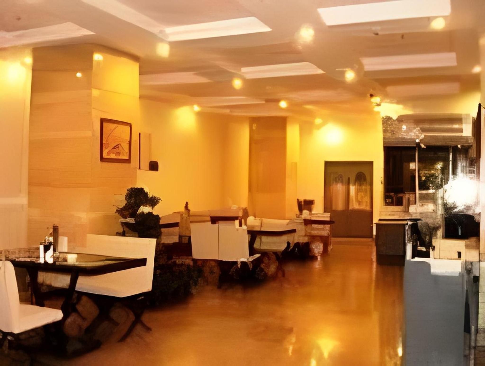 A restaurant with tables and chairs, a wooden floor, and a ceiling with recessed lighting.