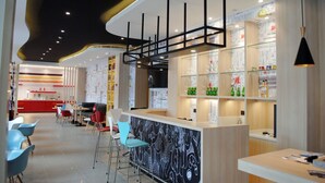 A modern bar area with a counter, bar stools, and shelves stocked with bottles. - Ibis Harbin Hongqi Street Hotel (Harbin)