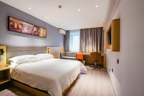 Une chambre d’hôtel avec un grand lit, un bureau, une chaise, une télévision et un tableau au mur.