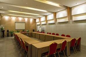 A conference room with a long table, red chairs, and a projector screen. - Jinjiang Inn (Shenyang Middle Street Metro Station, Imperial Palace) (Shenyang)