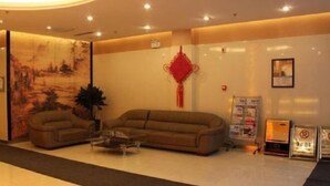 A lobby with a sofa, a coffee table, a red decorative item, a painting, and a framed picture on the wall. - Jinjiang Inn (Shenyang Middle Street Metro Station, Imperial Palace) (Shenyang)