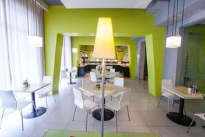 A modern dining area with tables and chairs, a central lamp, and a bar in the background. - Magnotel Chengdu Taikoo Li Dong Feng Bridge (Chengdu)