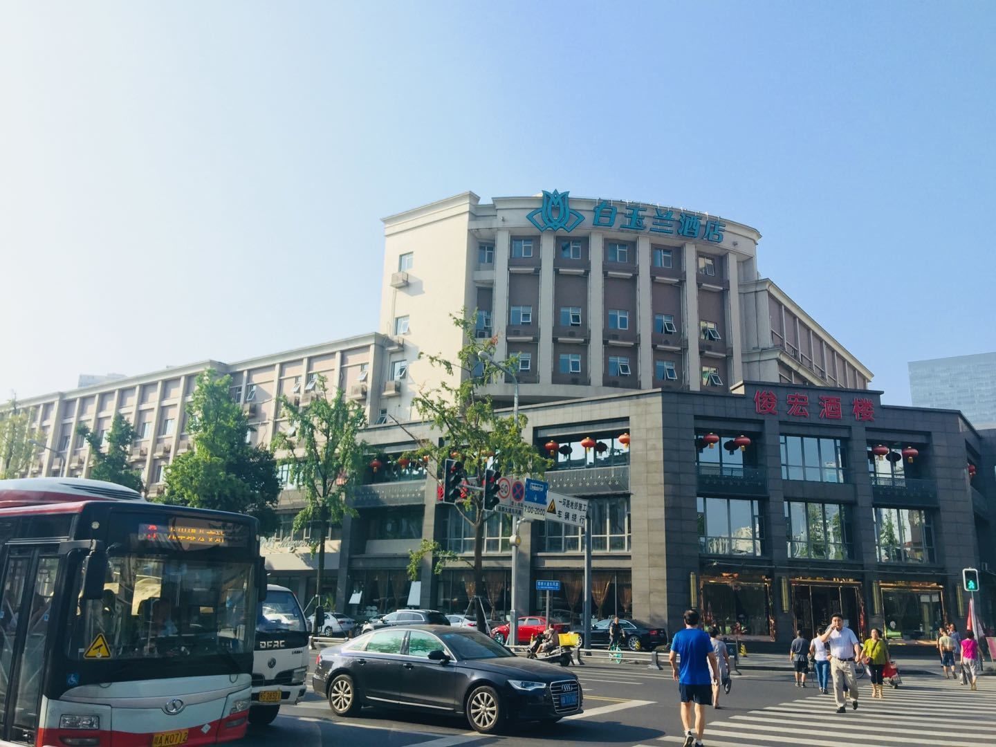 A hotel with a modern design, featuring a curved facade and multiple floors.