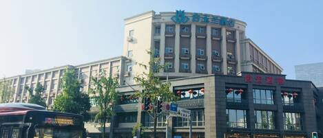 A hotel with a modern design, featuring a curved facade and multiple floors.