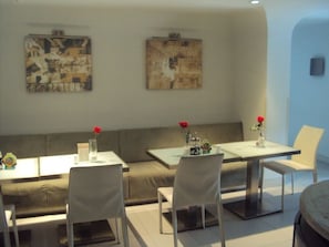 A modern dining area with a sofa, two tables, and chairs. - Jinjiang Inn Chendu Sport University (Chengdu)