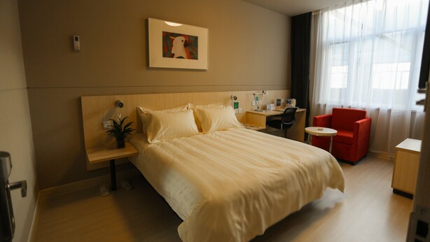 A hotel room with a bed, bedside table, lamp, chair, desk, and a window with curtains. - Jinjiang Inn Chongqing Shopping & Entertainment (Chongqing)