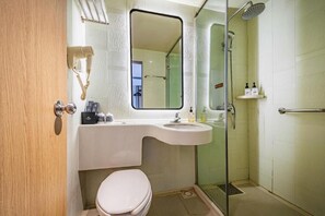 A bathroom with a toilet, sink, mirror, and shower. - Jinjiang Inn Chongqing Shopping & Entertainment (Chongqing)