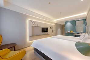 A modern hotel room with a large bed, a small desk, a chair, a TV mounted on the wall, and a bathroom with a mirror and sink. - Jinjiang Inn Guangzhou Haizhu Jiangyan Road (Guangzhou)