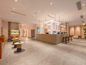 A modern reception area with a central desk, seating arrangements, and a digital display. - Jinjiang Inn Guangzhou Haizhu Jiangyan Road (Guangzhou)