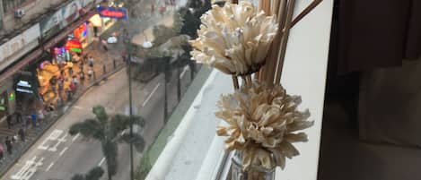 A view from a window with a decorative vase of dried flowers.
