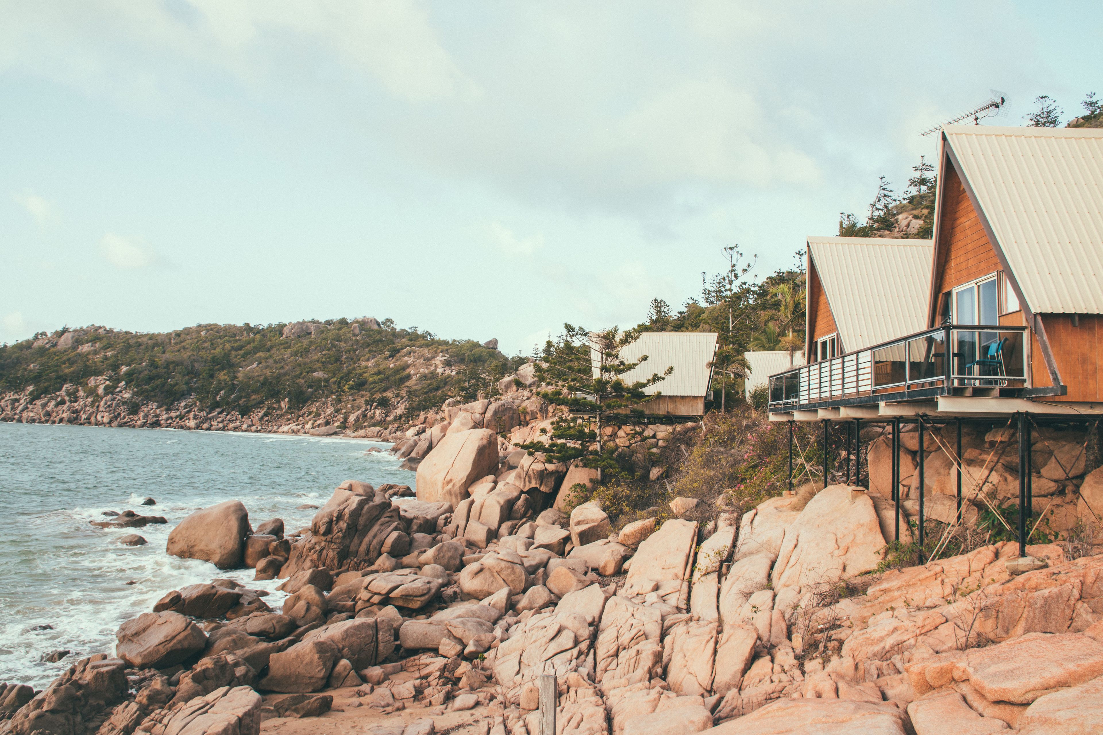 A coastal property with a rocky shoreline, wooden cabins, and a view of the sea.