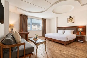 A hotel room with a bed, a sofa, a desk, a lamp, and a window with curtains. - Sky Gem Hotel - Ben Thanh (Ho Chi Minh City)