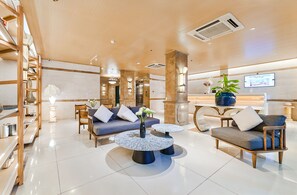 A modern hotel lobby with a reception desk, seating area, and a large screen displaying a welcome message. - Sky Gem Hotel - Ben Thanh (Ho Chi Minh City)
