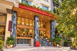 A hotel entrance with a red awning, large glass windows, and a staircase leading to the entrance. - Sky Gem Hotel - Ben Thanh (Ho Chi Minh City)