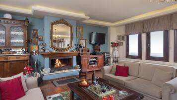 Una sala de estar con chimenea, televisor y sofá.