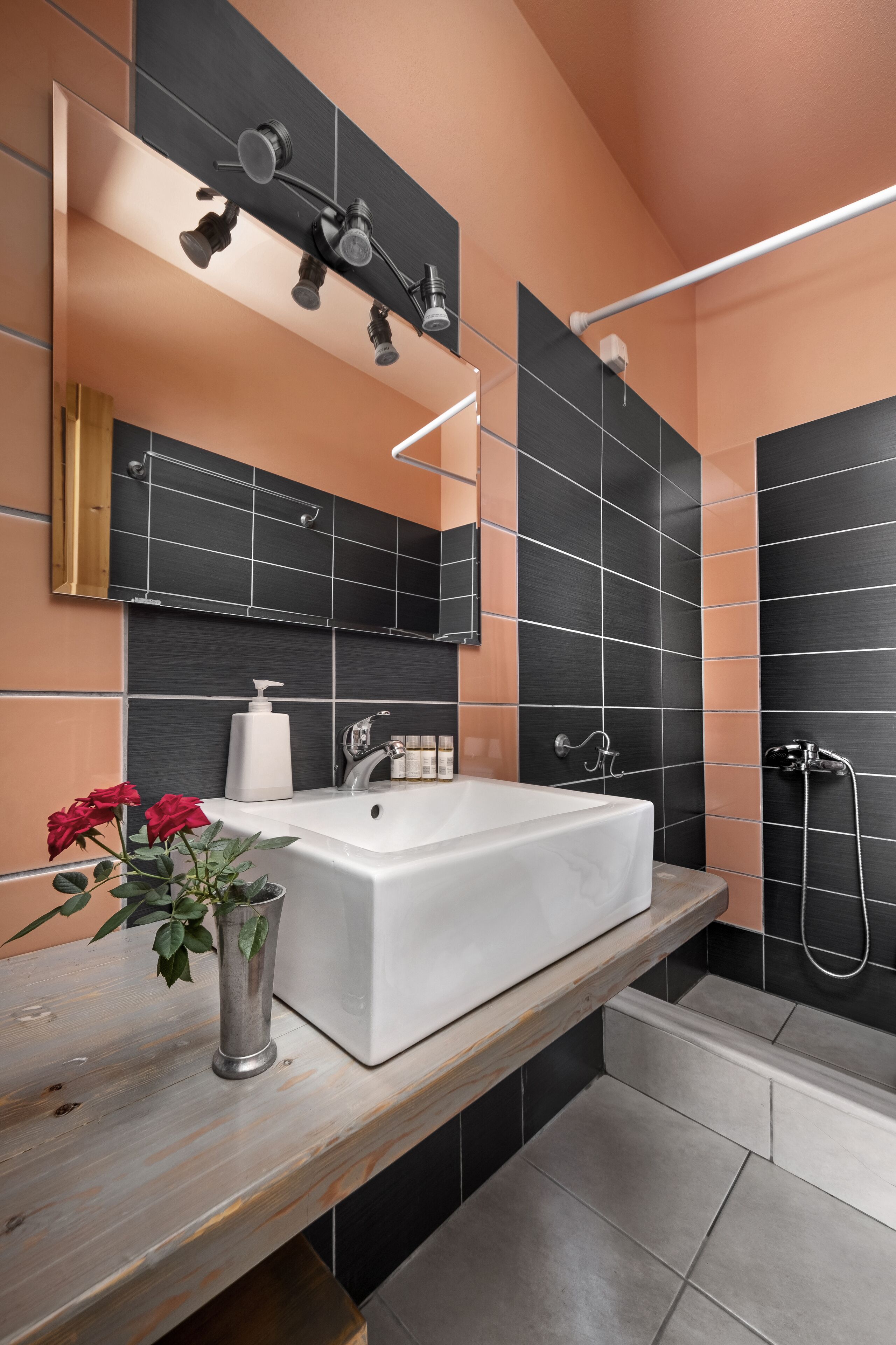 Een moderne badkamer met een groot wit bad, een houten wastafelmeubel, een spiegel en een douchegedeelte.
