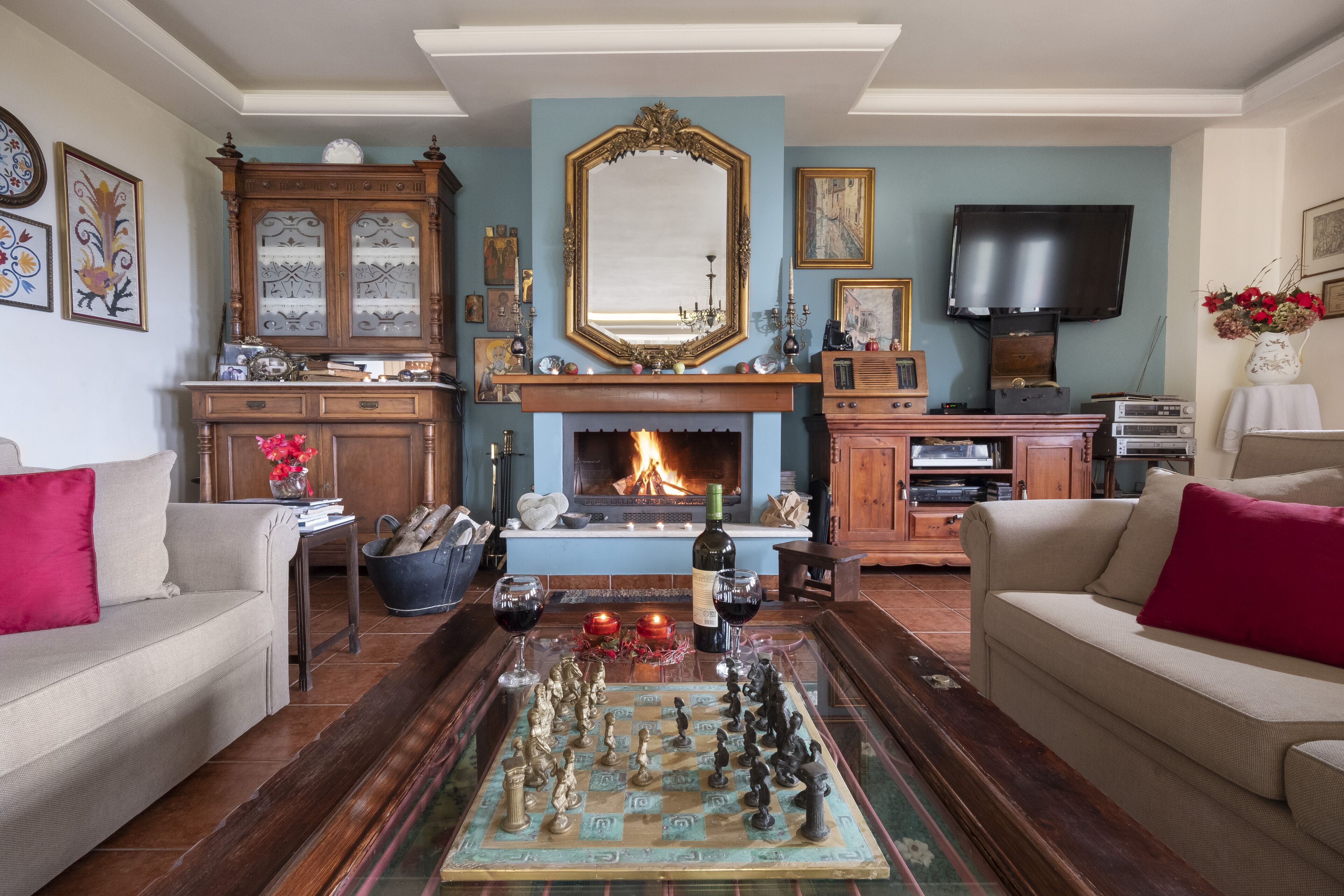 Una sala de estar con chimenea, un tablero de ajedrez y un televisor.