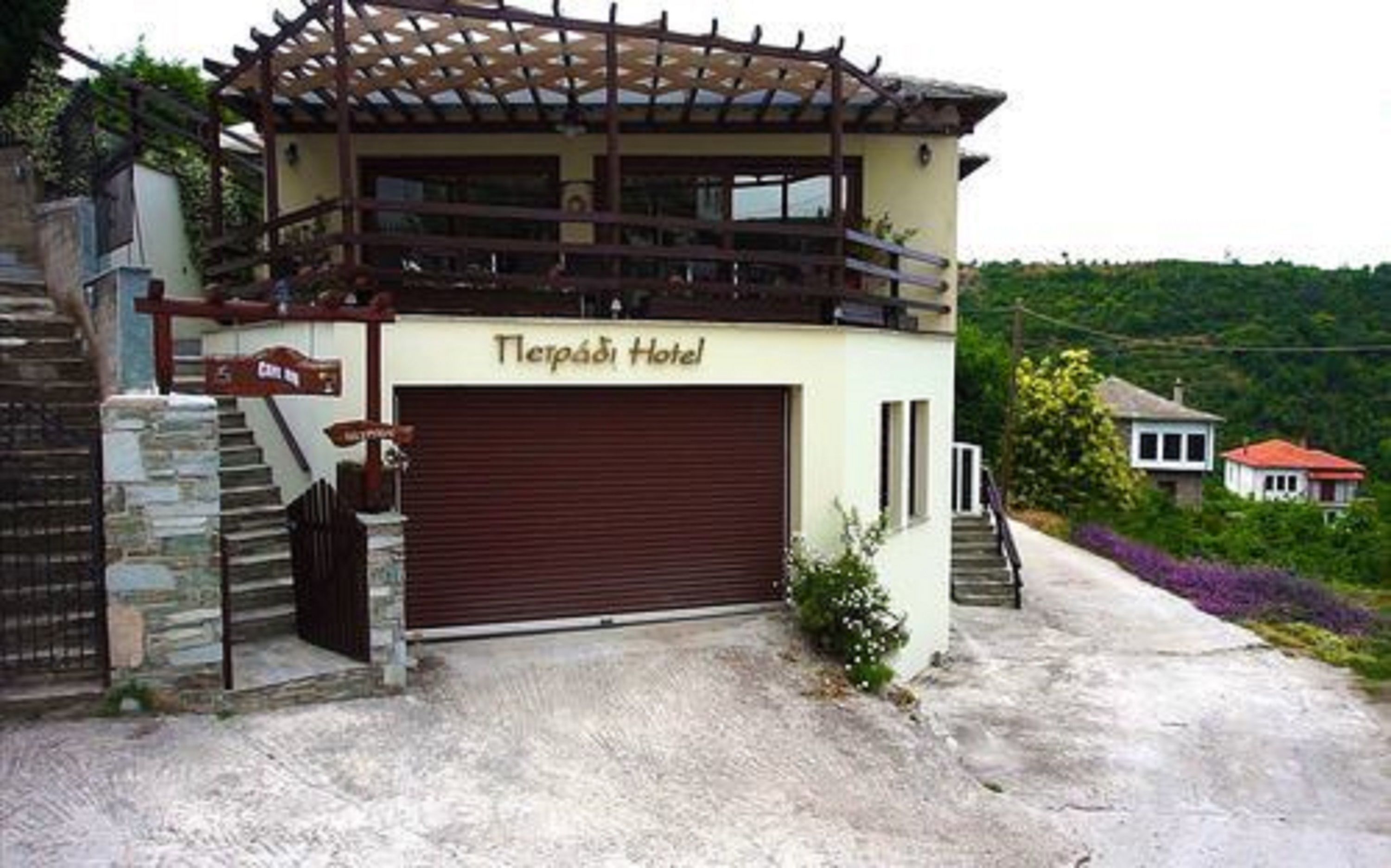 Un hotel con puerta de garaje cerrada, un balcón y un letrero que dice 'Terra Hotel'.