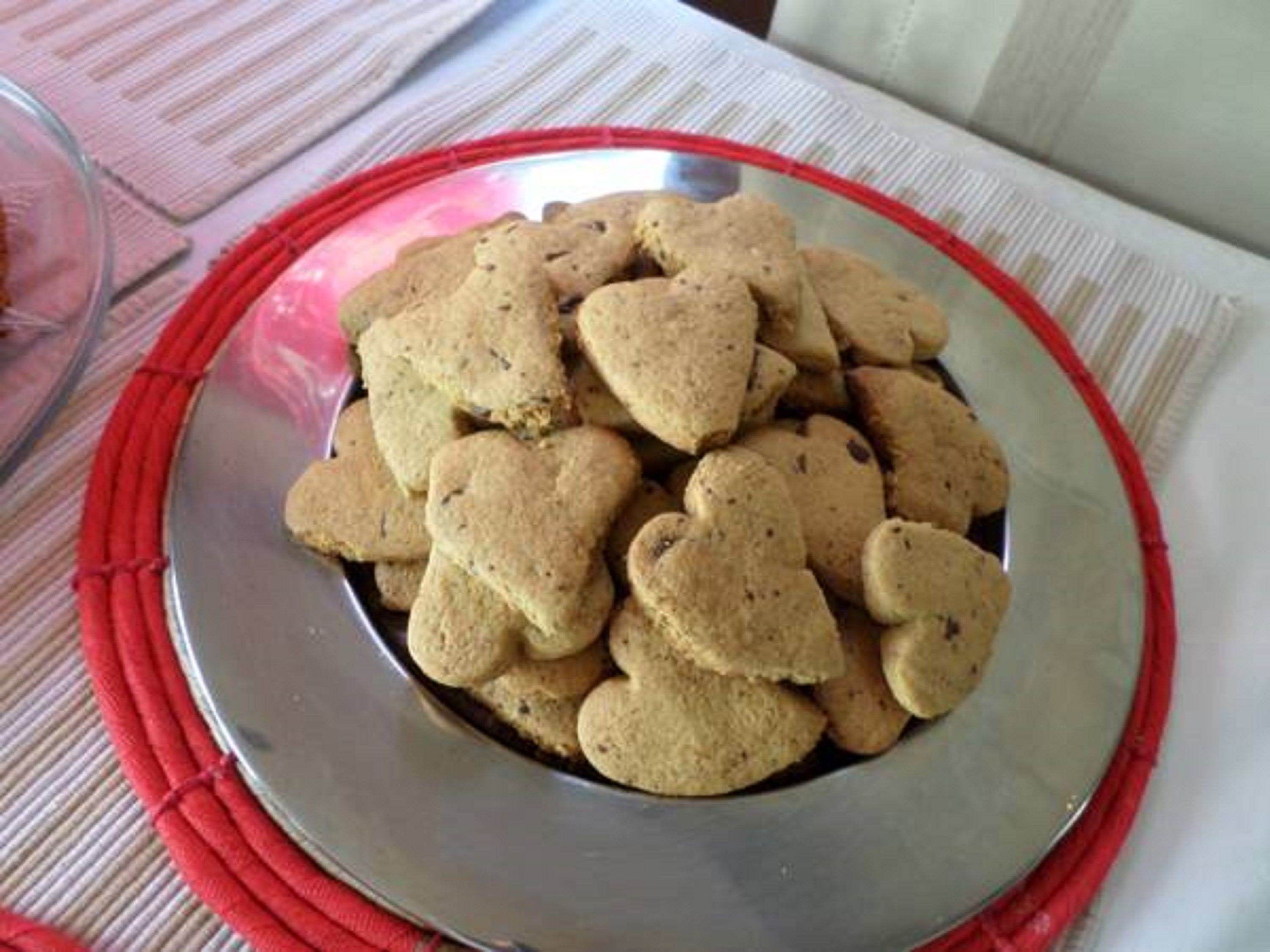 A plate of heart-shaped cookies on a metal tray.