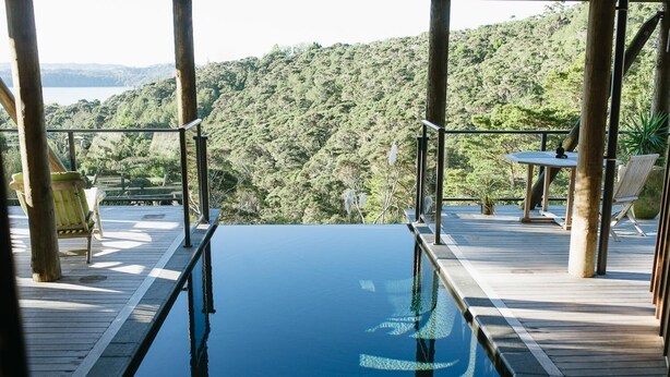 An infinity pool with a view of a forested hillside. - The Sanctuary @ Bay of Islands (Opua)