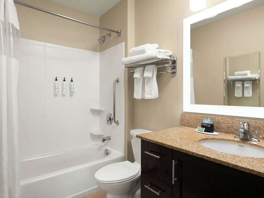 A bathroom with a bathtub, toilet, sink, and a mirror.