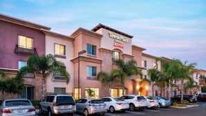 TownePlace Suites by Marriott con estacionamiento y palmeras.