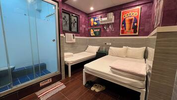 A hotel room with two single beds, a glass door, a small air conditioning unit, and a poster on the wall.