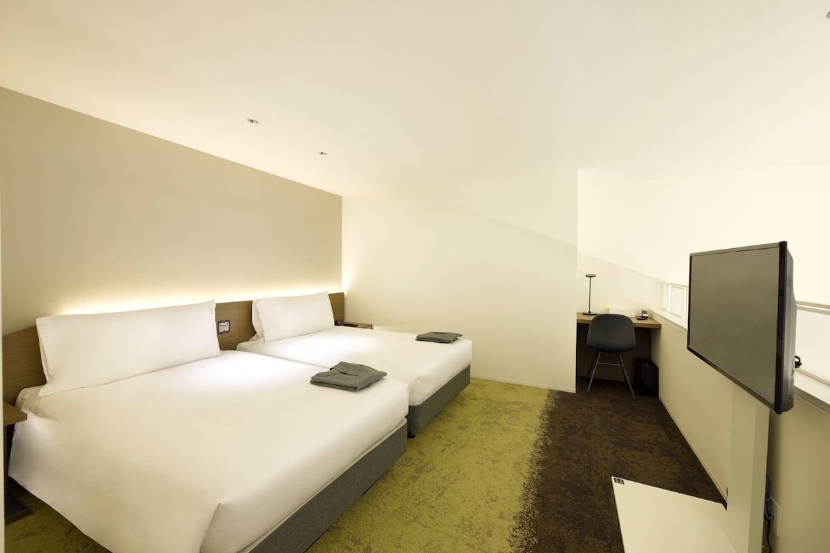 Een hotelkamer met een groot bed, een bureau en een televisie.