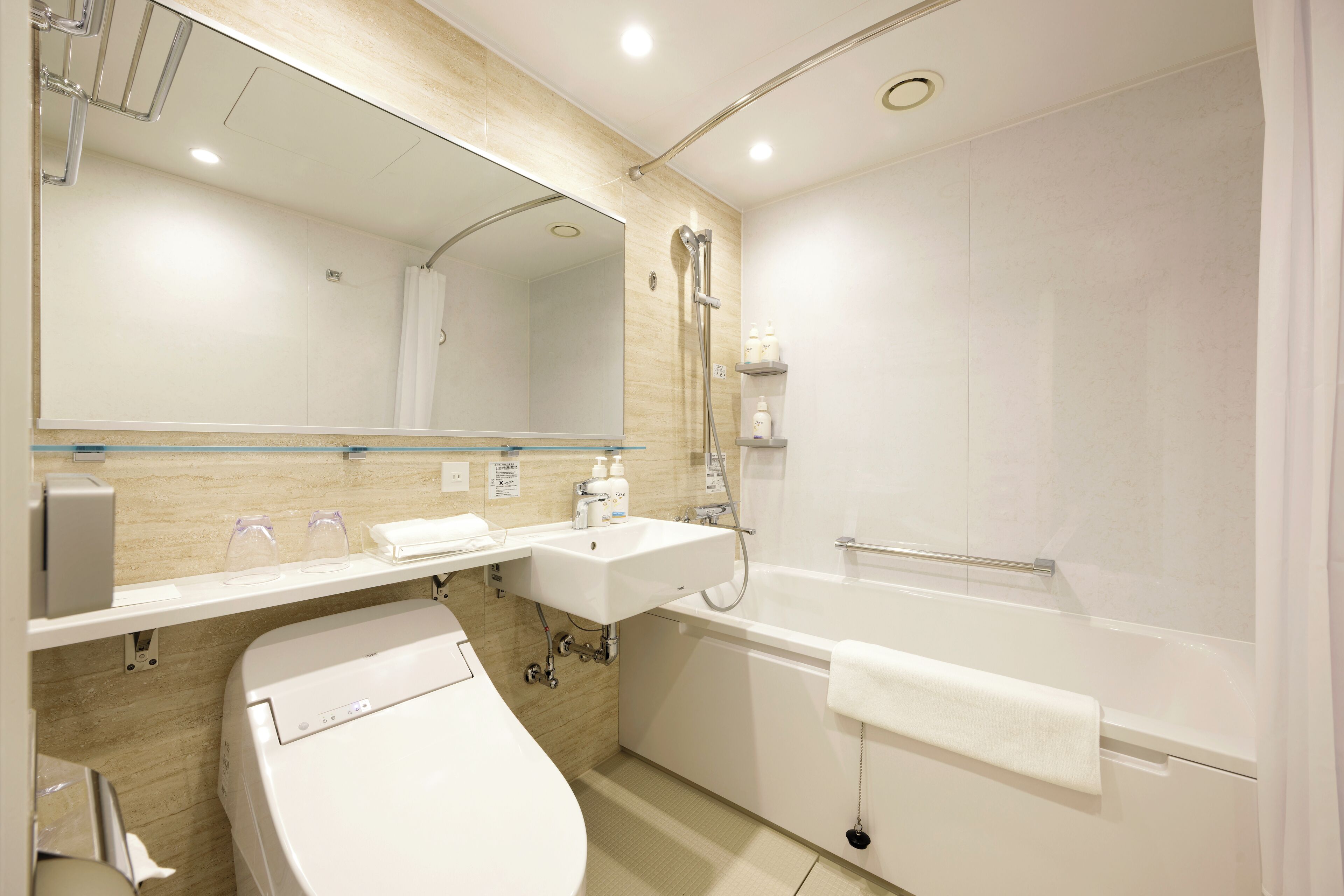 A modern bathroom with a toilet, sink, and bathtub.
